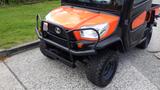 A 2018 Kubota RTV X1100C utility vehicle featuring an orange and black color scheme and a protective front bumper with rugged tires