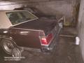 A brown 1982 Mercury Grand Marquis with a beige vinyl roof parked in a dimly lit garage