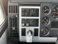 Interior dashboard controls of a 1994 Freightliner FL80 featuring various switches gauges and a key ignition