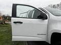 A white 2019 Chevrolet Colorado with its driver's side door open showcasing its sleek design and modern features