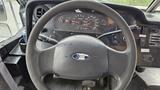 Close-up of the steering wheel and dashboard of a 2006 Ford Econoline showing the Ford logo gauges and controls