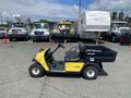 A 1999 Ez-go Industrial cart in yellow and black with a single seat and a flatbed cargo area on the back