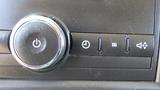 Close-up of the control panel in a 2012 GMC Savana featuring a dial for power and buttons for equalizer and settings