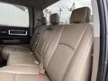 The image shows the interior of a 2010 Dodge Ram with beige leather seats in the back row