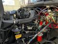 A 1994 Freightliner FL80 engine compartment showcasing various components including pipes wires and an engine block with visible labels and fluid containers