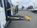 A 2017 Chevrolet Express with a yellow loading ramp extended from the rear entrance