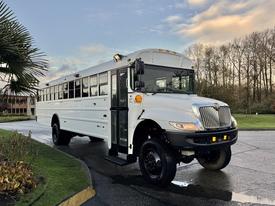 A white 2015 International 3000 school bus with large windows and a single door on the front side parked at an angle