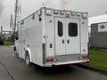 A white 2016 Chevrolet Express ambulance with a rear view featuring two doors and multiple lights on the top above the license plate area