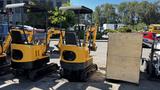 A yellow 2021 Cael-1T Mini excavator with a compact design and rubber tracks positioned next to a wooden crate