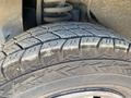 A close-up of a worn tire from a 2008 Ford Econoline showing visible tread pattern and debris on the surface