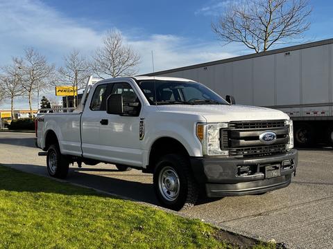 A white 2017 Ford F-250 pickup truck with a regular cab and a black front grille parked on a street