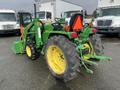 A green 2003 John Deere 790 tractor with large yellow tires and a front loader attachment