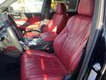 Interior of a 2023 Acura MDX showing red leather front seats and a modern dashboard with controls and a gear shift