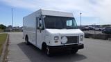 A 2011 Ford Econoline cargo van with a white exterior and no visible markings parked on a paved surface