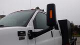 A white 2008 Chevrolet C7500 truck with a black side mirror and orange marker lights on the roof