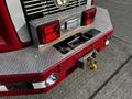 Red rear bumper of a 1994 Freightliner FL80 with chrome and diamond-plate detailing features lights a towing hitch and a winch