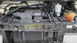 Engine compartment of a 2006 Ford Econoline showing the air intake and various engine components including hoses and fluid reservoirs