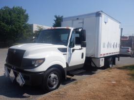 A white 2014 International TerraStar truck with a box cargo area and several reflective safety markings on the front and sides