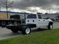 A white 2008 Dodge Ram 5500 cab and chassis with black wheels is parked on a street showing its side profile and open bed without any additional cargo