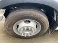 A close-up of a 2014 RAM 5500 tire showing a silver wheel with multiple bolts and a worn rubber tire with visible tread patterns