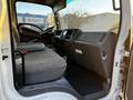 The interior of a 2017 Isuzu NPR featuring a driver's seat and dashboard with controls and storage compartments