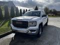 A white 2017 GMC Sierra 1500 pickup truck with a chrome grille and sleek design parked in a lot