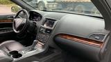 Interior view of a 2013 Lincoln MKT showing leather seats a console with gear shifter and an infotainment screen with various controls and trim accents