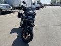 A 2021 Harley-Davidson RA1250 S motorcycle in a standing position with a sleek black body and fork-mounted accessories