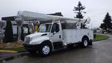 A white 2005 International 4300 bucket truck with an extended hydraulic lift and storage compartments on the side