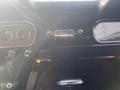 Interior dashboard of a 1966 Ford Mustang featuring vintage dials a radio and a gear shift with a key in the ignition