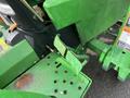 A close-up view of the foot pedals and control area of a 2003 John Deere 790 tractor showcasing the green components and texture of the pedals