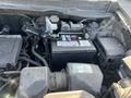 An engine compartment of a 2012 Kia Sportage featuring a car battery and various engine components including hoses and fluid reservoirs