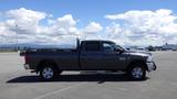 A gray 2014 RAM 3500 with a crew cab and a flatbed in a parking lot