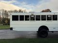 A 2015 International 3000 bus featuring a white exterior with large windows and black wheels