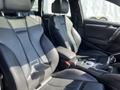 Interior of a 2016 Audi A3 featuring black leather seats and a console with gear shifter and control knobs