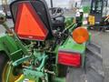 2003 John Deere 790 tractor showing the rear view with a red triangle safety sign and orange rear light visible on the left side