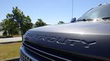 Close-up of the front grille and hood of a gray 2017 Ford F-350 SD featuring the words SUPER DUTY embossed on the metal surface