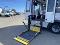 A 2017 Chevrolet Express with a wheelchair lift in the foreground and a seat positioned for accessibility