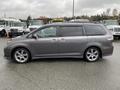 A gray 2013 Toyota Sienna minivan viewed from the side showcasing its sleek design and alloy wheels