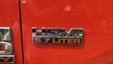 A chrome badge displaying "HEMI 5.7 LITER" on the side of a red 2013 RAM 2500 truck