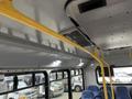 Interior view of a 2017 Chevrolet Express showing yellow grab bars ceiling lights and blue passenger seats