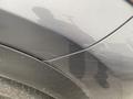 A close-up view of a 2021 Lexus NX 300 showing a scratched area on the passenger side door with a reflective surface