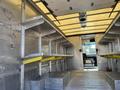 Interior of a 2012 Ford Econoline with metal shelving and steps leading to the cabin