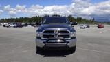 A blue 2014 RAM 3500 truck with a chrome grille and black front guard is parked in a lot facing the camera