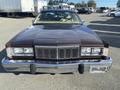 A 1982 Mercury Grand Marquis with a brown exterior and chrome accents positioned head-on showcasing its distinctive grille and headlights