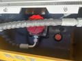 A close-up view of the engine compartment of a 2024 AGT KTT23 Mini Skid Steer featuring hoses and a red cap on a fluid reservoir