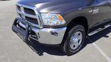 A 2014 RAM 3500 with a shiny chrome grille and a black grille guard attached to the front, showcasing a large wheel with all-terrain tire treads