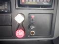 Dashboard controls of a 2006 International 4300 featuring a red trailer air supply switch a power outlet and a black switch and indicator lights