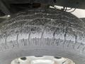 Close-up of a 2013 Ford F-150 tire showcasing tread patterns and water droplets on the surface