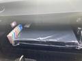 Glove compartment of a 2020 Land Rover Range Rover Sport contains a black folder and a colorful pack of ice pops